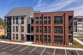 A modern building with a parking lot in front.