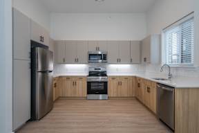 A modern kitchen with wooden cabinets and stainless steel appliances.