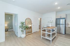 A kitchen with a table and a plant in a vase.