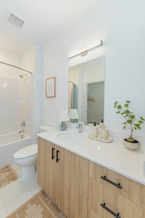 A bathroom with a toilet, sink, and mirror.