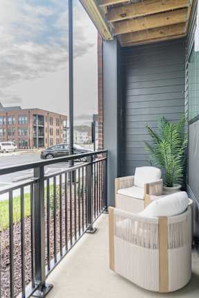 A balcony with a chair and a table.