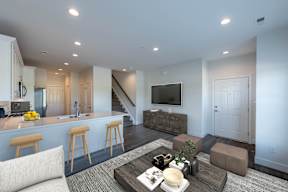 A modern living room with a bar area and a staircase.