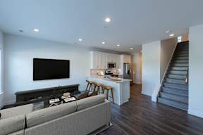 A living room with a grey couch and a black television.