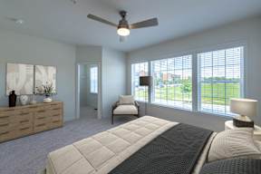 A bedroom with a large bed and a ceiling fan.