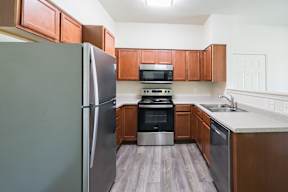 A kitchen with a refrigerator, oven, and microwave.