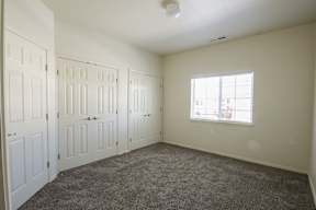 A room with white doors and a window with a view of a city.