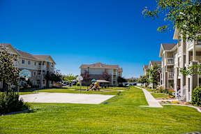 A sunny day at a residential complex with a playground in the middle.