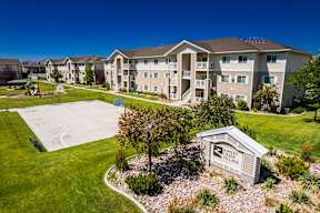A view of a Shelby Village apartment complex with a playground and a sign.