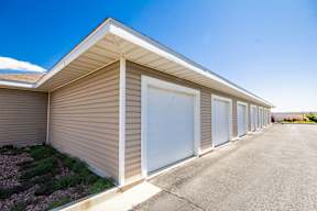 A long building with a brown siding and a white roof.