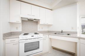 a kitchen with white cabinets and a white stove top oven