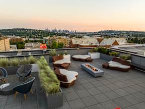 A rooftop patio with a fire pit and seating area.