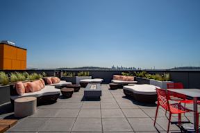 A rooftop patio with red chairs and tables.
