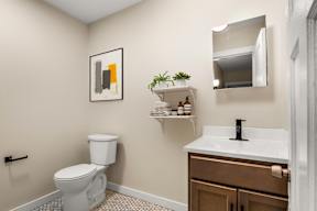 a bathroom with a toilet and a sink and a mirror