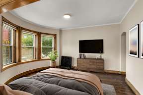 a bedroom with a bed and a tv on the wall