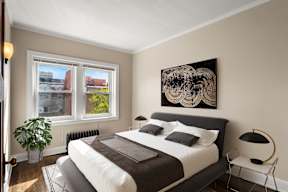 a bedroom with a bed and two windows