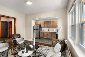 a living room with a couch and a table and a kitchen