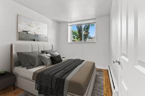 A bedroom with a large bed and a painting on the wall.