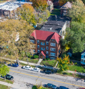 an aerial view of a building with a red roof and a street