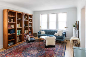 a living room with a blue couch and a bookshelf