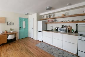 a kitchen with white cabinets and a green door