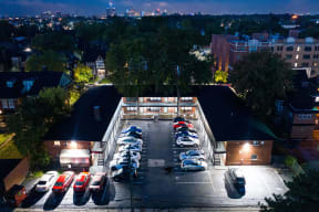 an aerial view of a parking lot at night with cars parked