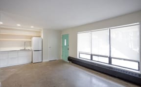 an empty living room with large windows and a carpeted floor