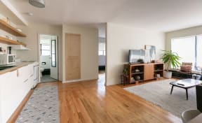 an open living room and kitchen with a wood floor
