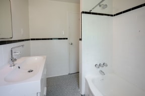a white bathroom with two sinks and a shower