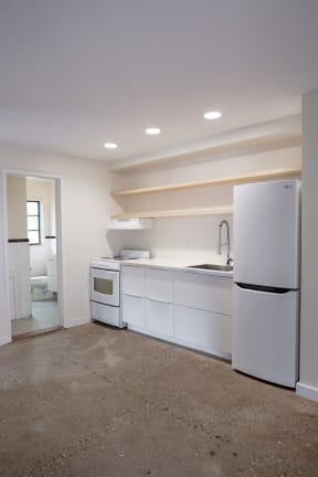 a kitchen with white cabinets and a refrigerator and a sink