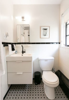 a bathroom with a toilet and a sink and a mirror