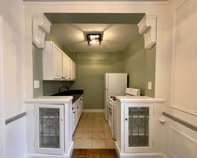 a kitchen with white cabinets and a white refrigerator