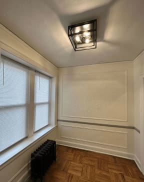 a dining room with a large window and a light fixture