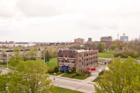 an aerial view of a building in a park with a city in the background