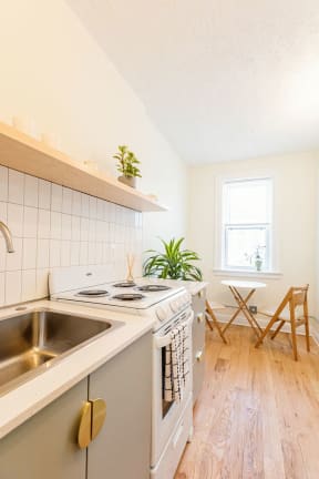 a kitchen with a stove and a sink and a window