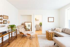 a living room with a couch and a chair and a mirror