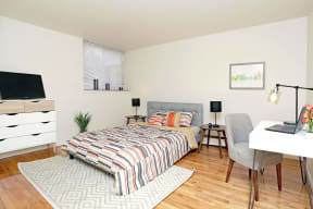 a bedroom with a bed and a desk with a laptop