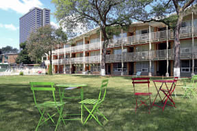 a group of chairs and tables in front of an apartment building