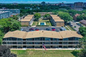 an aerial view of a building with a brown roof and a city in the background