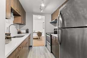 A modern kitchen with a large refrigerator and wooden cabinets.