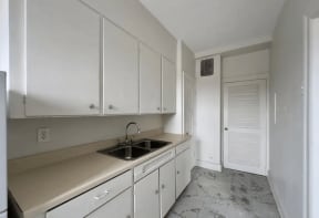 the kitchen of a home with white cabinets and a sink