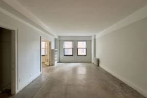 an empty living room with white walls and a door and window