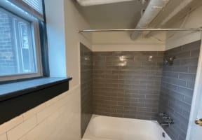 a bathroom with a window and a sink and a tub