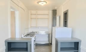 an empty kitchen with a stove and a refrigerator