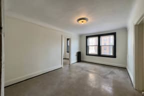 the living room of an empty apartment with a large window