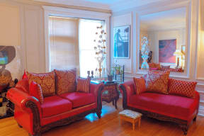 a living room with two red chairs and a table