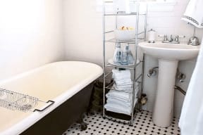 a white bathroom with a tub and a sink