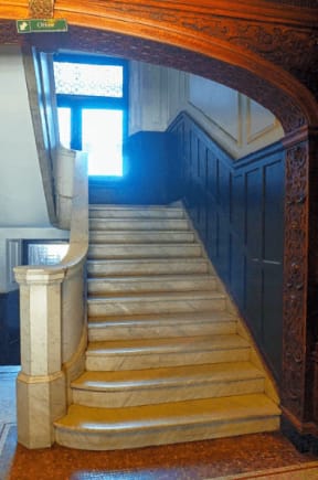 the stairs in a building with a blue door