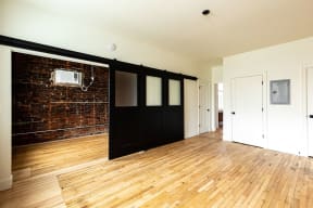 a living room with a wood floor and a sliding barn door