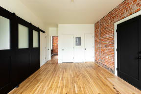 a row of black and white doors in a room with wooden floors