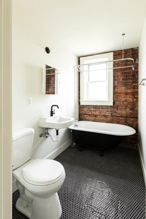 a bathroom with a toilet and a sink and a bath tub